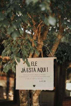 a sign hanging from the side of a tree that says, el jeesta aoui