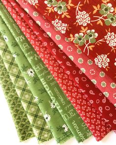 several different types of fabric are lined up together on a white table top, with one red and the other green