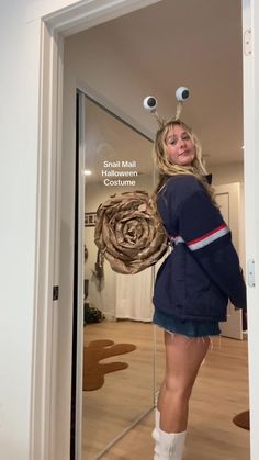 a woman standing in front of a mirror with her legs crossed and holding a large object