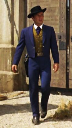 a man in a blue suit and hat is walking