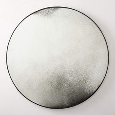 a black and white circular mirror on the wall