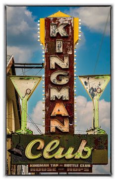 an old neon sign with martini glasses on top