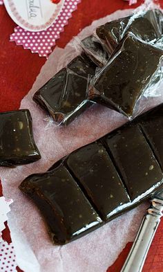 pieces of chocolate sitting on top of a piece of wax paper next to a knife