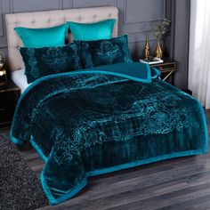 the bed is covered in teal velvet