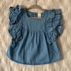 Brand New With Tags Denim Top With Ruffle Sleeves Button Down Back Size 6-12 Months Beautiful Chambray Material Bought While Traveling Europe And Never Got A Chance To Wear. Similar To Zara Kids, Hanna Andersson, Aden Anais, Carters, Oshkosh, Primary, Kate Quinn Loc: Kids D Cute Denim Blue Cotton Tops, Cotton Ruffle Tops For Playdate, Cute Denim Tops For Summer, Cute Summer Denim Tops, Denim Ruffled Short Sleeve Tops, Cute Blue Denim Tops, Cute Blue Tops For Playdate, Blue Short Sleeve Top For Playdate, Cute Blue Top For Playdate