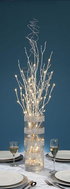 the table is set with white plates and silverware, which are accented with lights