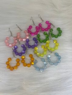 Hi Everyone,   Cute earrings in shop, Handmade Earrings, Pink, Light Pink, Orange, Green, Yellow, Purple, Blue, Medium Beads, Silver Hoop Earrings. Handmade fashion jewelry accessories perfect gifts for her and for a special friend. Can be for everyday look for women and her fashion accessory. The length is about less then 2 inches from top to bottom. And the wide is about less then an 1 inches to side to side. There is purple, blue, orange, yellow, green, Pink, Light Pink earrings, $5.00 each. You pick which color.  Thank you for looking at my jewelry shop. Trendy Round Beaded Earrings With Ear Wire, Hoop Earrings With Dangling Round Beads For Gifts, Hoop Earrings With Dangling Round Beads As Gift, Hypoallergenic Round Beaded Earrings For Party, Round Beads Hoop Earrings With Ear Wire For Party, Hypoallergenic Beaded Earrings For Party, Trendy Earrings With Round Beads And Ear Wire, Silver Wire Earrings, Wire Jewelry Designs