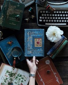 a person is holding an old book in front of several other books on a table