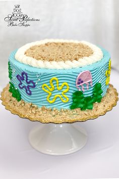 there is a blue cake with animals on it and sand in the top tiers