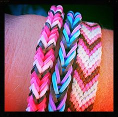 two different colored bracelets are on someone's arm, one is pink and the other is blue