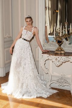 a woman standing in front of a mirror wearing a wedding dress