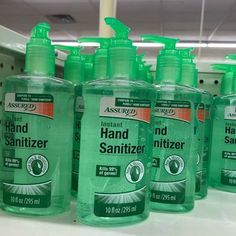 several bottles of hand sanitizer sitting on a shelf in a store or department