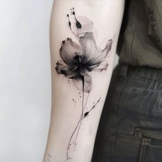 a black and white flower tattoo on the arm