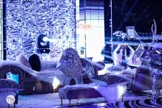 a room filled with lots of furniture covered in purple and white furnishing next to a window