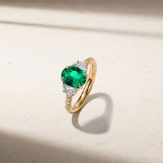 Classic meets modern in this exquisite ring incorporating a striking oval shape emerald that is contrasted by a pair of brilliant half moon diamonds set on each side of the center stone. Petite round diamonds are studded along a portion of the shank to offer an additional touch of sparkle. The ring has been thoughtfully designed with a low profile so that it sits flush against the finger. Metal: 18kt Gold Emerald Weight: 1.45 ct. Half Moon Diamond Weight: 0.61 ct. Round Diamond Weight: 0.07 ct. Luxury Oval Three Stone Emerald Ring, Luxury Oval Emerald Ring With Three Stones, Oval Brilliant Cut Emerald Ring, Oval Emerald Ring With Diamond Accents For May Birthstone, Green Oval Diamond Ring Fine Jewelry, Green Oval Diamond Ring With Center Stone, Oval Diamond Ring With Side Stones, Fine Jewelry, Oval Diamond Ring For May Birthstone, Luxury Oval Emerald Ring With Brilliant Cut