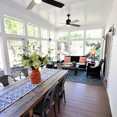 a dining room table with chairs and a ceiling fan in the middle of an open floor plan