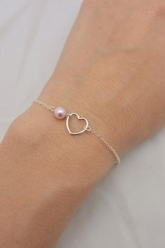 REAL STERLING SILVER - A QUALITY GIFTI make this beautiful bracelet using a delicate sterling silver heart charm set on sterling silver chain (all 925 sterling). A 6mm Swarovski pearl completes the look and is available in your choice of five colors. Secures with a lobster clasp and comes in a gift box, perfect for gift-giving. These make great group gifts.SIZING - IMPORTANT: To determine bracelet size, measure around your wrist and add 1/2 inch to get your bracelet size. Do not order in your ex Pink Heart-shaped Sterling Silver Bracelets, Pink Heart-shaped Sterling Silver Bracelet, Pink Heart-shaped Sterling Silver Charm Bracelet, Dainty Sterling Silver Heart Bracelet, Pink Heart Charm Bracelet In Sterling Silver, Dainty Heart-shaped Sterling Silver Bracelet, Dainty Sterling Silver Bracelets For Valentine's Day, Sterling Silver Heart Pendant Bracelet For Valentine's Day, Sterling Silver Heart Charm Bracelet For Mother's Day