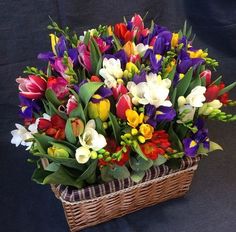 a basket filled with lots of colorful flowers