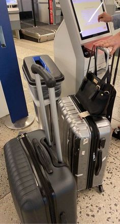 several pieces of luggage sitting on top of a floor next to an airport check in kiosk