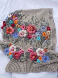 an old sweater with flowers on it is laying on the bed and has been made to look like something out of fabric