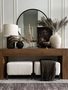 a wooden table topped with a mirror and two stools