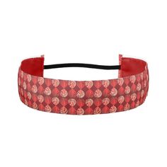 a red headband with circles and dots on the side, in front of a white background