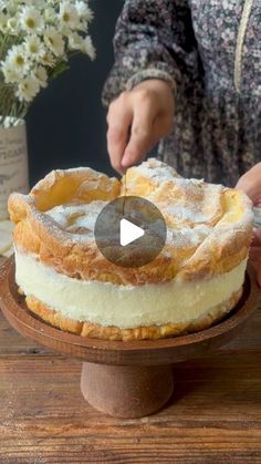 a person is decorating a cake with icing and powdered sugar on top