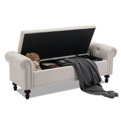 a white couch with a blanket and stuffed animals in it's storage compartment on wheels