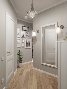 an empty hallway with pictures on the wall and wood flooring in front of it