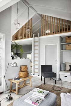 a living room filled with furniture and a staircase leading to the top floor above it