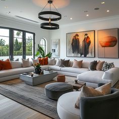 a living room filled with lots of furniture and large paintings on the wall above it