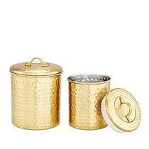 three gold canisters with lids on each one and the lid is open to reveal something