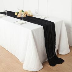 the table is set with white and black linens