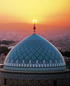 the sun is setting over an ornate dome