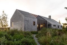 the house is surrounded by tall grass and trees