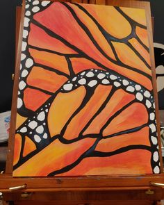 an easel with a painting of a butterfly on it