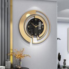 a clock that is on the side of a wall next to a vase with flowers