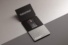 a black and silver business card with a red cross on it's front side