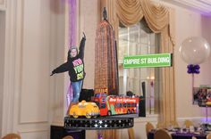 a statue of a person standing on top of a table in front of a sign that says empire st building