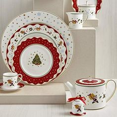 a christmas themed table setting with red and white dishes