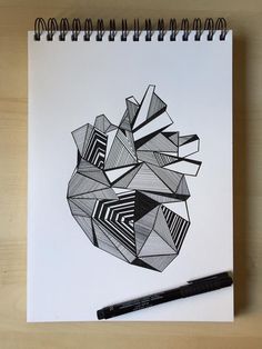 a spiral notebook with an abstract design on it next to a pen and paper clippings