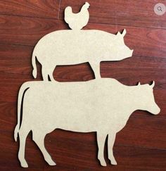 two wooden cutouts of cows on top of each other