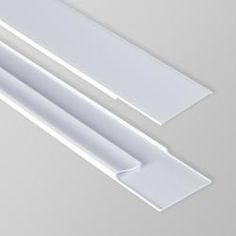 two white plastic objects on a gray surface