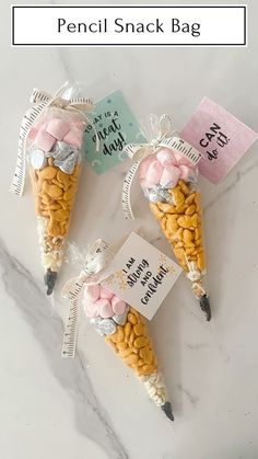 three small candy cones wrapped in cellophane and tied with ribbon on top of a marble counter