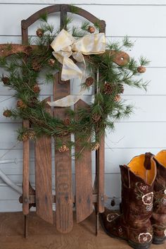 a pair of boots sitting next to a wooden sled with pine cones on it