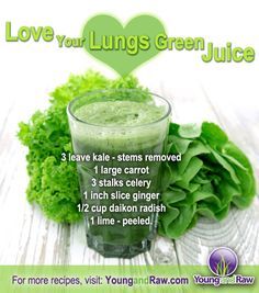 a green juice is in a glass next to some lettuce and other vegetables