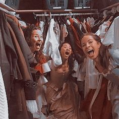 three women are laughing while hanging out in the closet