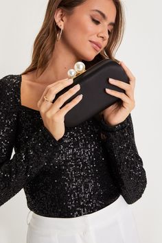 Complete any sophisticated party look with a perfect finishing touch like the Lulus Poised Feelings Black Satin Pearl Box Clutch! Sleek satin shapes this chic box clutch that has a rectangular silhouette and a top clasp closure composed of oversized faux pearl details. The roomy, lined interior with accordion sides is perfect for storing your night-out essentials, while a detachable gold chain allows you to style it as a crossbody! Lined. Bag measures 7. 5" Wide, 4" tall, 2. 25" deep. Chain meas Chic Rectangular Clutch For Party Season, Elegant Square Clutch For Formal Occasions, Rectangular Evening Bag For Party Season And Night Out, Glamorous Formal Clutch For Party Season, Elegant Square Formal Clutch, Black Rectangular Clutch For Parties, Chic Clutch For Night Out And Party Season, Chic Clutch For Night Out Party Season, Chic Clutch For Night Out In Party Season