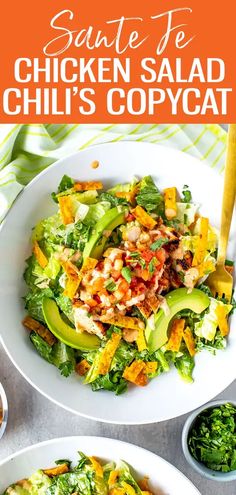 two white plates filled with chicken salad and topped with avocado, lettuce