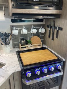 a stove top oven sitting inside of a kitchen next to a wall mounted microwave above it